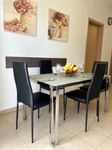 - une table à manger avec des chaises et des verres à vin dans l'établissement Swieqi sunny central airy quiet Apartment in Malta, à Is-Swieqi