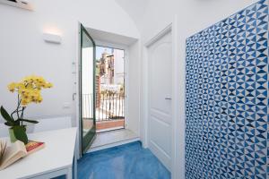 a hallway with blue tile on the wall at Secret Amalfi - Your stay in downtown Amalfi in Amalfi +33 photos