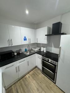 a kitchen with white cabinets and black counter tops at Juniper Berry in Southampton