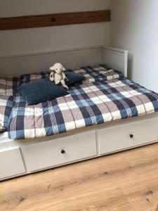 a teddy bear sitting on top of a bed at Land-Loft in Hilgermissen