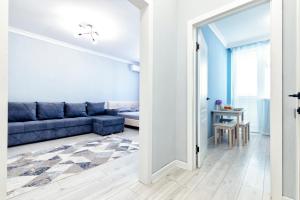 a living room with a blue couch and a table at Уютная кв в ЖК Комсомольский in Taldykolʼ