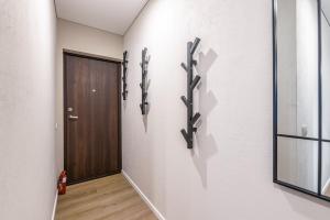 a hallway with a door and a wall with weapons at Stylish gray studio near the city center in Vilnius