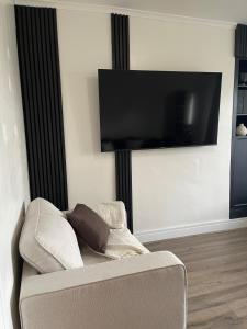 Una sala de estar con un sofá y un televisor de pantalla plana. en Sheffield Contemporary Elegant Getaway, en Wincobank