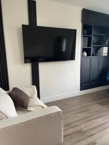 sala de estar con TV de pantalla plana grande en la pared en Sheffield Contemporary Elegant Getaway, en Wincobank