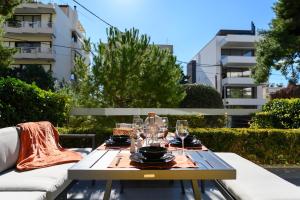 a table with wine glasses and plates on it at Athenian Riviera Prestige 2 bedroom in Athens