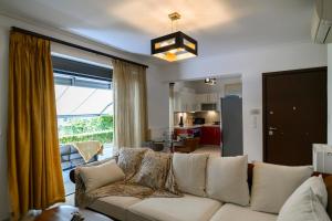 a living room with a white couch and a large window at Athenian Riviera Prestige 2 bedroom in Athens