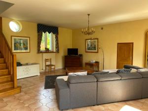 a living room with a couch and a television at Loire Valley Cottages in Jarzé