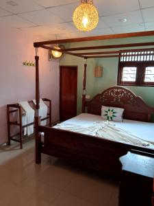 a bedroom with a large bed with a wooden frame at Celon vie Beachfront Hotel Ahangama in Ahangama