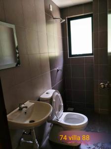 a bathroom with a toilet and a sink and a window at 74 pangkorocean villa88 in Kampong Sungai Udang