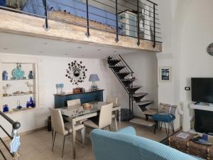 a living room with a table and chairs and a staircase at La chiave di Philoxenia in Ostuni