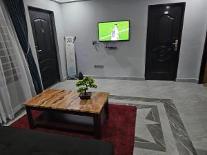 a living room with a table and a tv on a wall at New appartement for reasonable price in Weija +2 photos