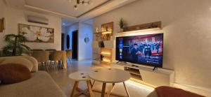 a living room with a flat screen tv on a wall at Appartement charmant au parc de Mohammedia, à seulement 2 pas de la plage in Mohammedia
