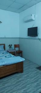 a bedroom with a bed and a tv on the wall at Khách sạn Phương Đông 2 in Thuan An