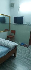a bedroom with a bed and a mirror and a chair at Khách sạn Phương Đông 2 in Thuan An