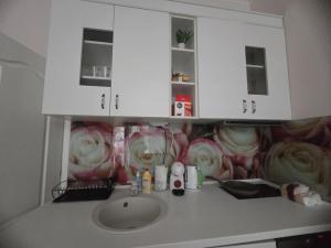 a bathroom counter with a sink and white cabinets at Roses in Sofia +18 photos