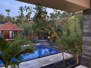 a garden with a swimming pool in a yard at Villa Indah Anugrah in Kubu