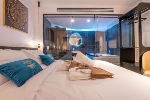 una camera da letto con un grande letto bianco con cuscini blu di Cesia Boutique a Biriyya