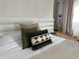 a white bed with a white headboard and two pillows at Casa da Villa in Vila Nova de Foz Coa