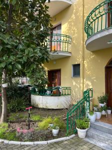 un edificio amarillo con un árbol y un balcón en Vacation Apartments Garden, en Golem