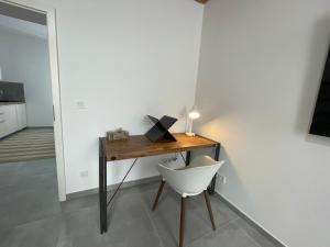 einen Schreibtisch mit einem weißen Stuhl neben einem Zimmer in der Unterkunft Danisman Apartments 3 Zentral - Smart - Modern in Saarbrücken