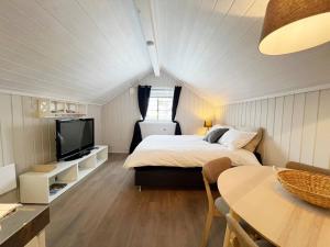 a bedroom with a bed and a tv and a table at La Casa Roja in Sandefjord