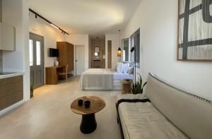 a hotel room with a bed and a couch and a table at Salvia di Astypalea in Livadi Astypalaias