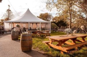 a picnic table and a white tent in a field at The Robinhood Inn - Drouin in Drouin West