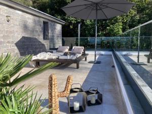 eine Terrasse mit Pool und Sonnenschirm in der Unterkunft Blue Horizon Luxury Villa in Senhora do Rosário + 22 Fotos