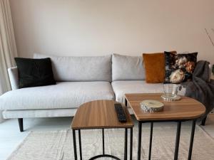 a living room with a couch and two tables at Gateway to Amsterdam in Almere