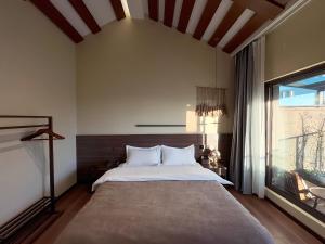 Un dormitorio con una cama grande y una ventana grande. en Luyu Shijian B&B, en Lijiang