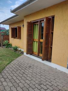 a house with wooden doors and a walkway at Casa Aconchegante in Monte Belo