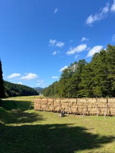 a field with a row of hay fences at うご八かやぶ㐂 in Narazaki