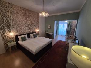 a bedroom with a large bed and a bathroom at Penzion PIANO & Apartment Sokolov in Sokolov
