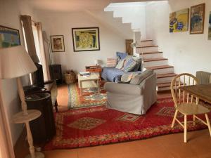 a living room with a couch and a staircase at Cozy Country House near Beaches in Azoia