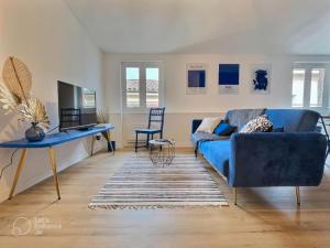 a living room with a blue couch and a table at Le Bleuet au cœur de Valence in Valence