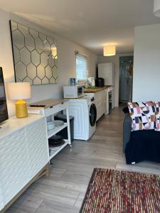 a kitchen and living room with a washer and dryer at Leysdown Beach Escape in Sheerness