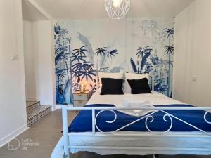 a bedroom with a bed with blue and white wallpaper at Le Bleuet au cœur de Valence in Valence
