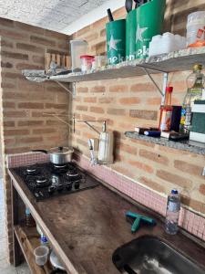 a kitchen counter with a stove and a sink at Guaecá Hostel - Cumuruxatiba in Cumuruxatiba +37 photos