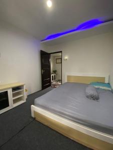 a bedroom with a large bed with blue lights on it at Alfaz Homestay in Garung