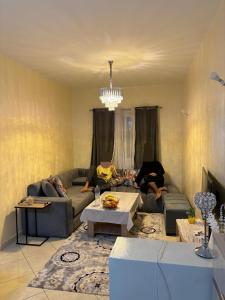 un homme assis sur un canapé dans un salon dans l'établissement Appartement skhirat, à Skhirat