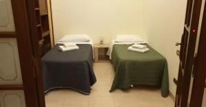 2 łóżka w pokoju z zieloną pościelą i ręcznikami w obiekcie The Dante Apartment By HouseinNaples w mieście Neapol +15 zdjęć