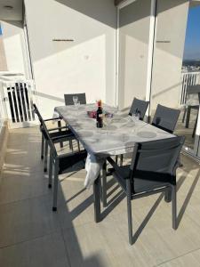 una mesa con sillas y una botella de vino en el balcón en Sunset View, Mellieha, Malta, en Mellieħa 63 fotos más