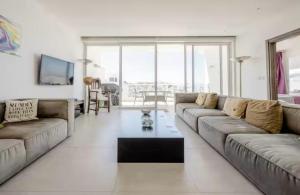 Una sala de estar con dos sofás y una mesa de café. en Sunset View, Mellieha, Malta, en Mellieħa