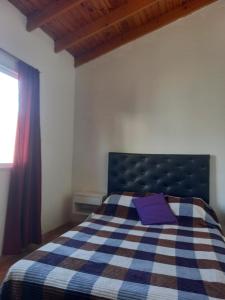 une chambre avec un lit avec une couverture bleue et blanche dans l'établissement Alojamiento temporario 2, à Lanús