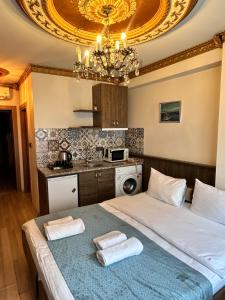 a bedroom with two beds and a kitchen with a chandelier at taksim white family suites in Istanbul