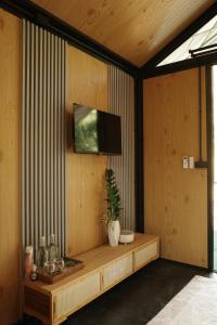 ein Zimmer mit einem Fernseher an einer Holzwand in der Unterkunft Baanraisongshul K&E Gardens in Khlong Lan