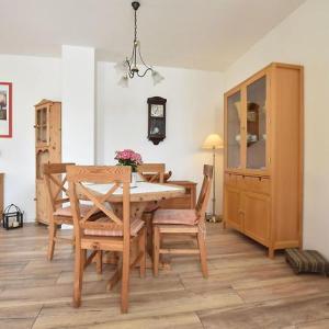 a dining room with a table and chairs and a clock at Ferienwohnung Klast F51 in Kühlungsborn