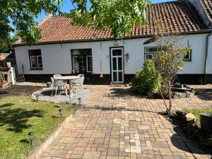 a white house with a table and chairs in the yard at Het relax hoeveke in Ostend