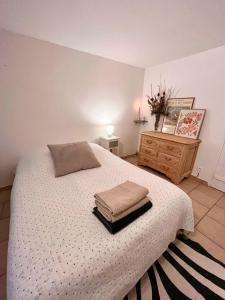 a bedroom with a bed with two towels on it at Studio du Mesnil in Équemauville