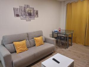 ein Wohnzimmer mit Sofa und Tisch in der Unterkunft APARTAMENTOS COSTA XUÑO in Porto do Son